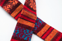 Close-up detail of a woven tapestry strap with bold multicolor stripes and geometric patterns