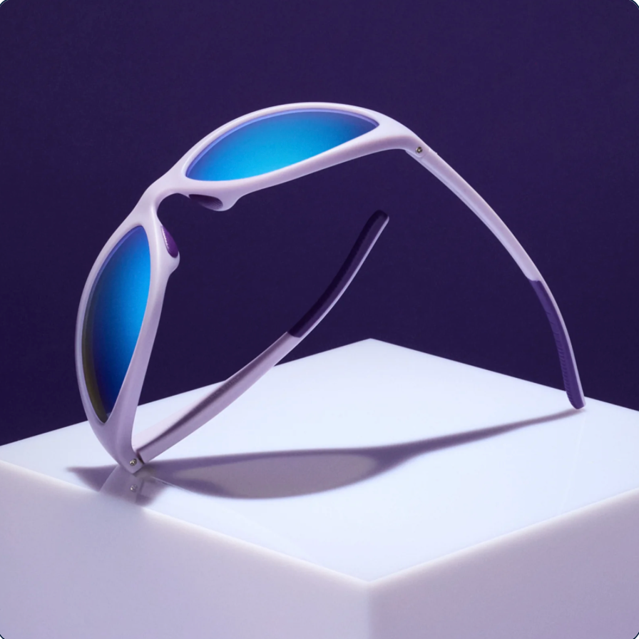 Wraparound sunglasses with lavender frame and blue mirrored lenses displayed upright on white surface