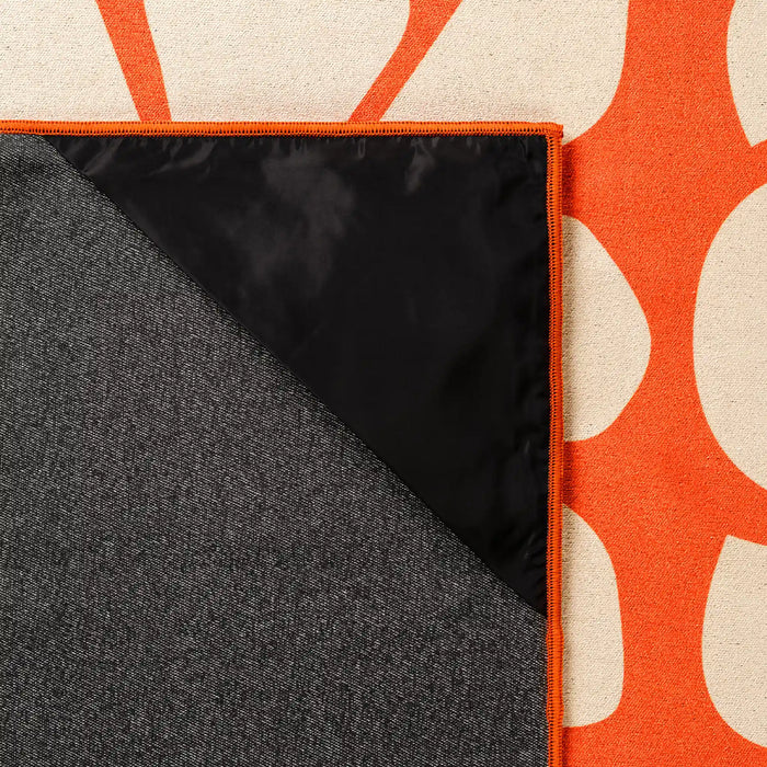 Reversible blanket towel with orange floral pattern on one side and gray on reverse