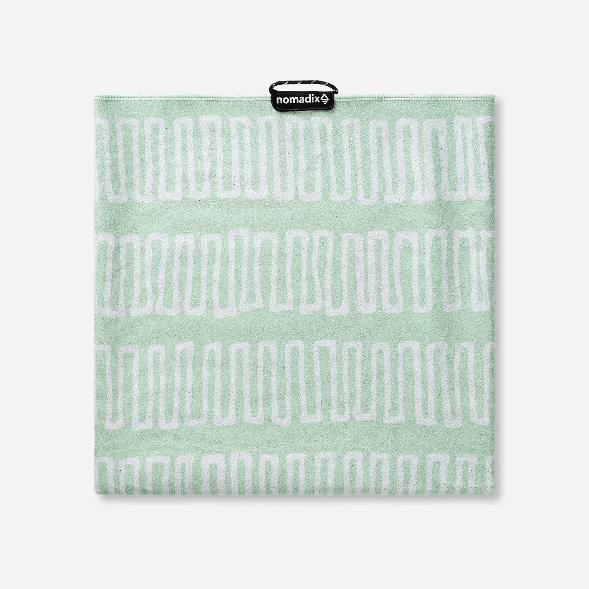 Light green towel with white geometric zigzag pattern displayed flat against white background