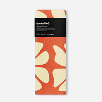 Orange and cream patterned blanket towel in packaging on white background