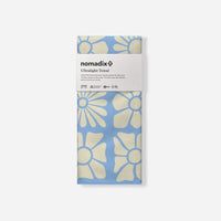 Packaged ultralight towel with floral pattern in blue and cream colors, studio shot