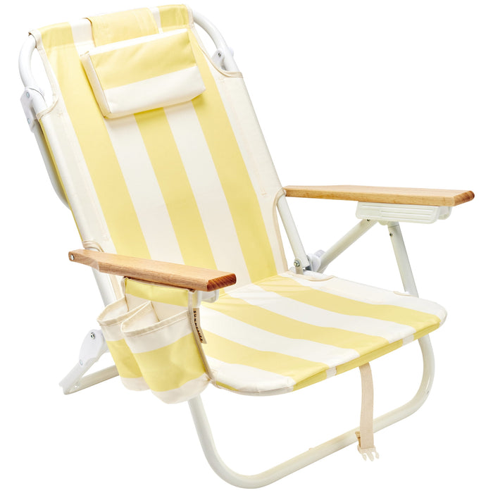 Yellow and white striped beach chair with wooden armrests and white metal frame