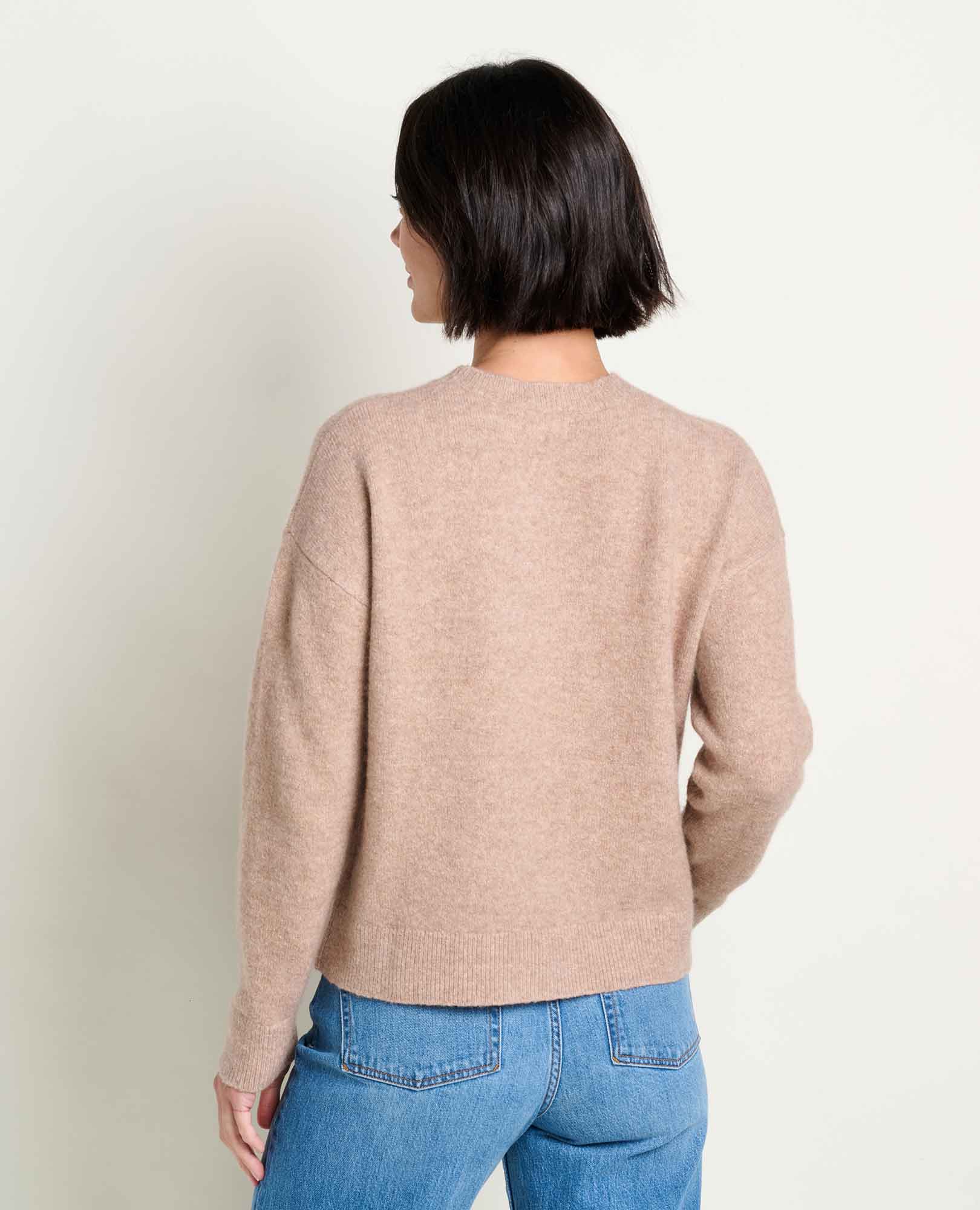 Women's crew neck pullover sweater in tan heathered knit, back view, paired with blue jeans