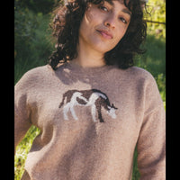 Women's crew neck knit sweater in beige with brown and white horse intarsia pattern, on-model lifestyle shot