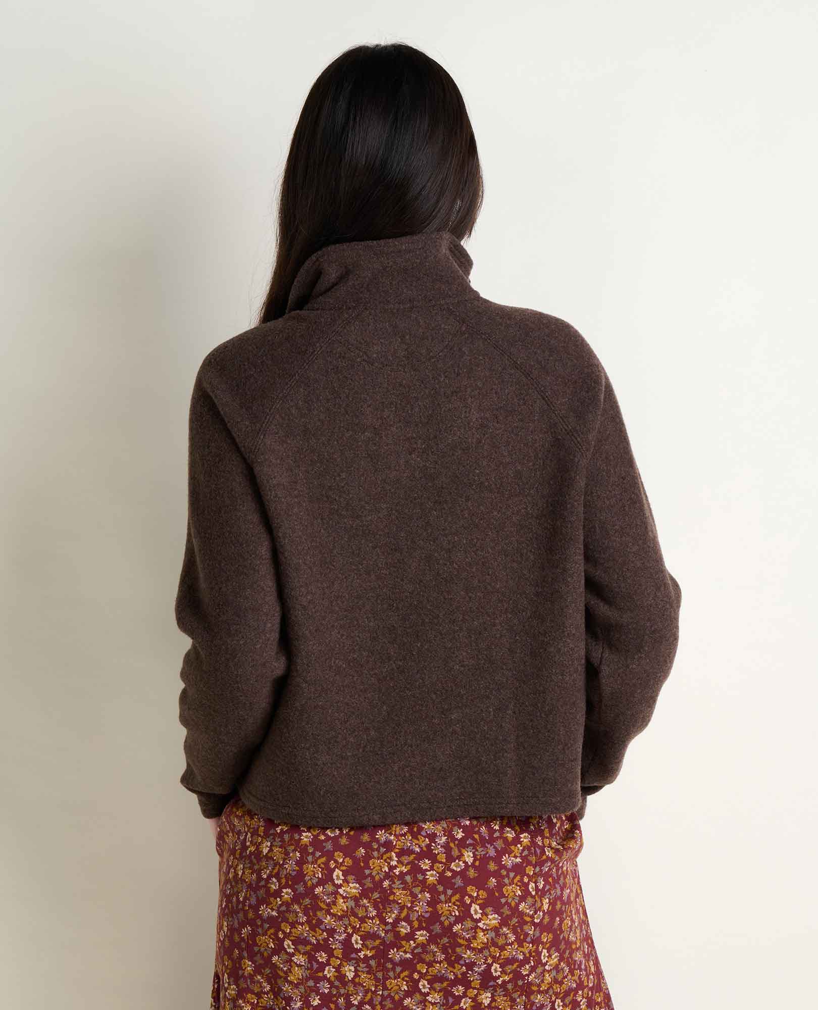 Women's quarter-zip fleece pullover in dark brown, back view, paired with floral skirt