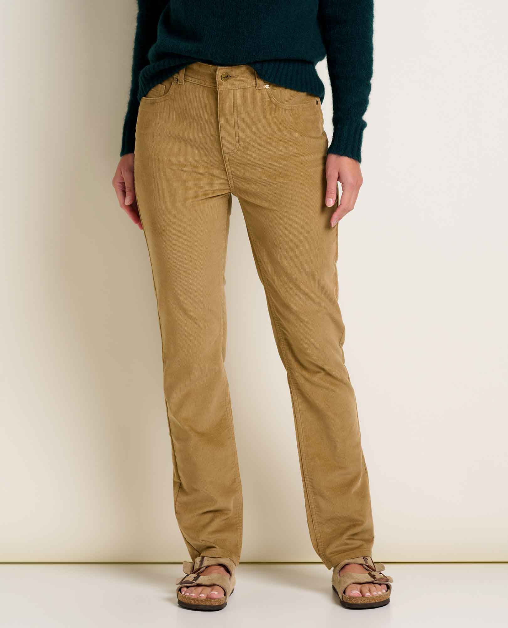 Women's slim-fit corduroy pants in warm tan, front view, paired with sandals