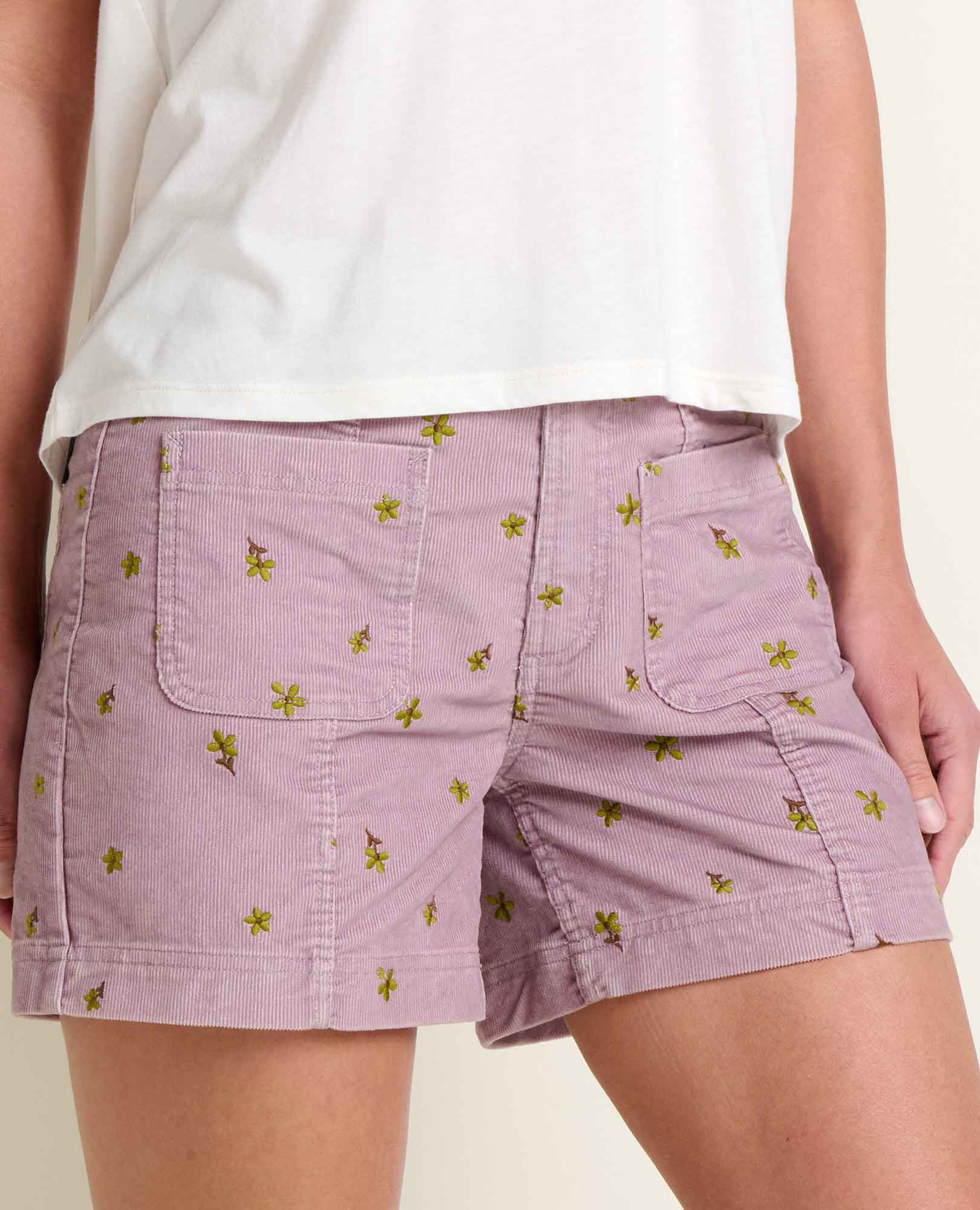 Light purple corduroy shorts with small green floral embroidery, front view on model