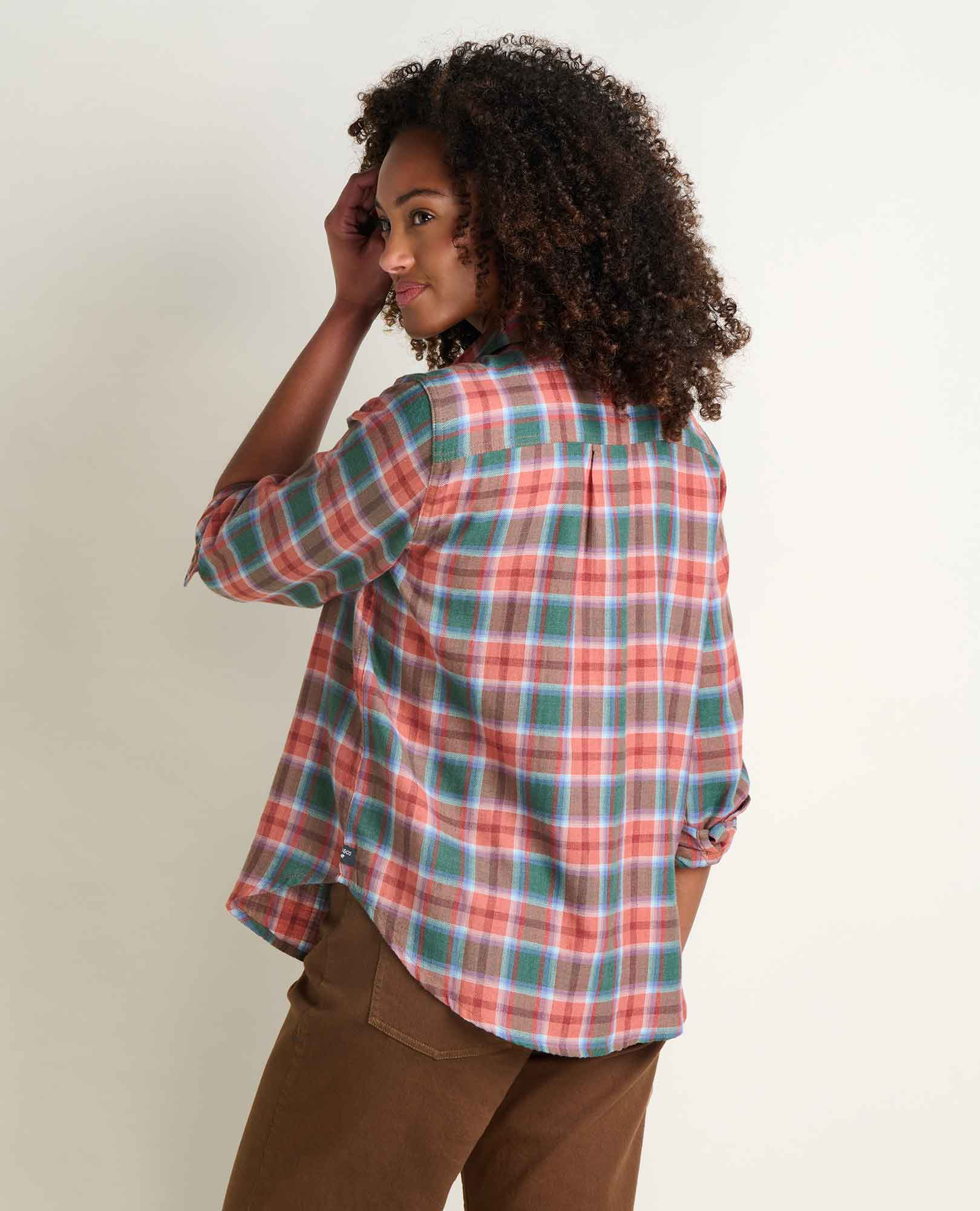 Women's plaid flannel shirt in coral and teal check, back view on model with rolled sleeves