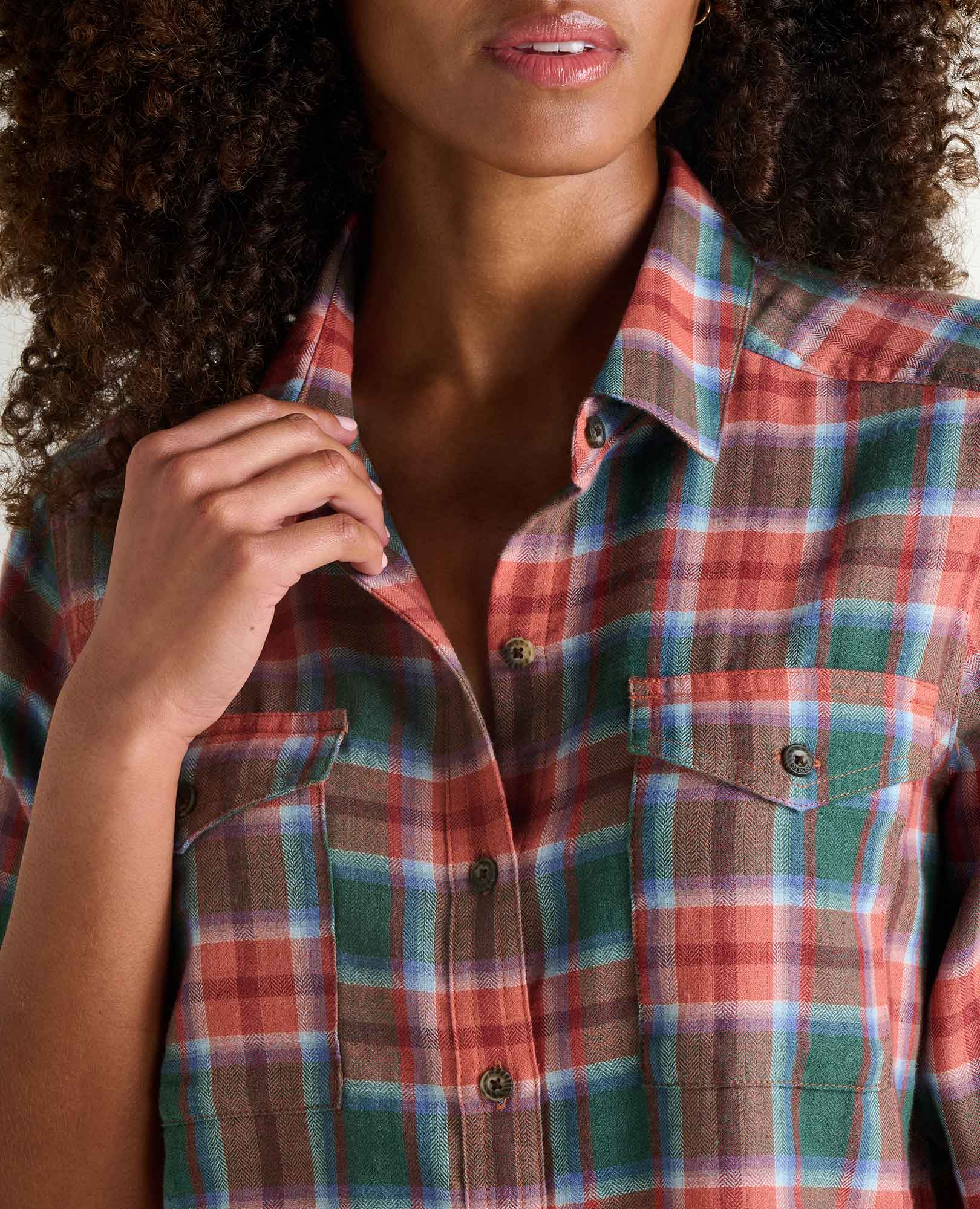 Women's plaid flannel button-up shirt with chest pockets, close-up detail view on model