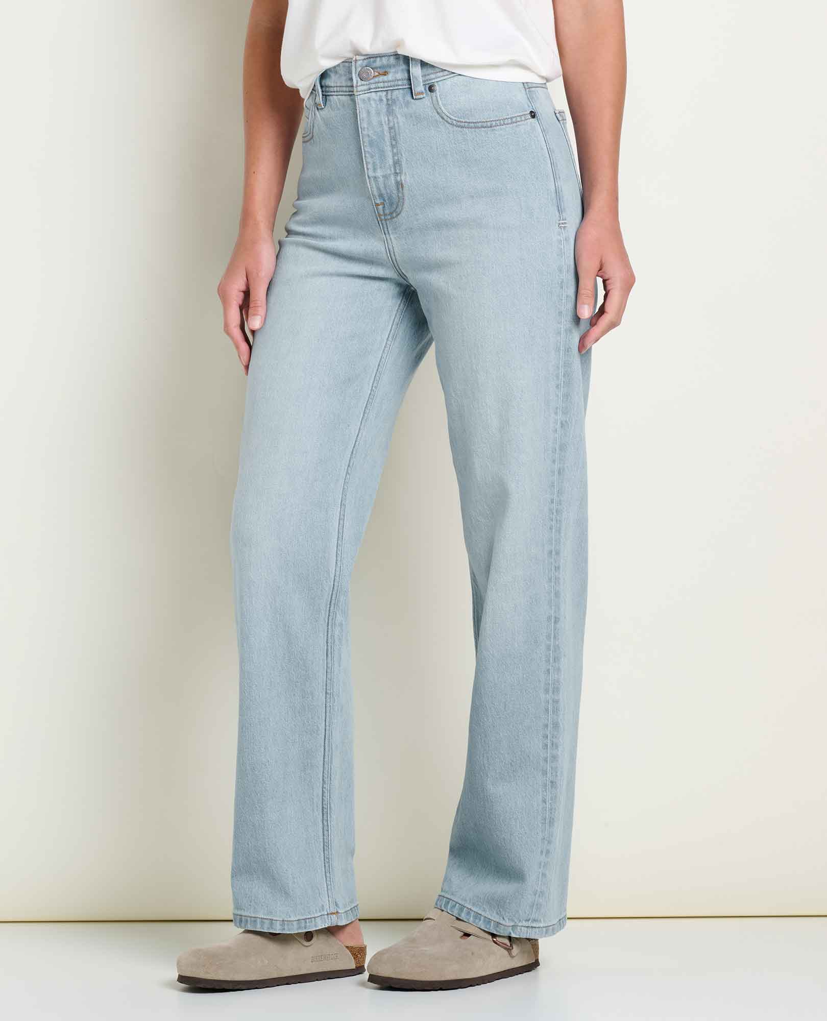 Women's high-rise straight leg light wash jeans, front three-quarter view, worn with sandals