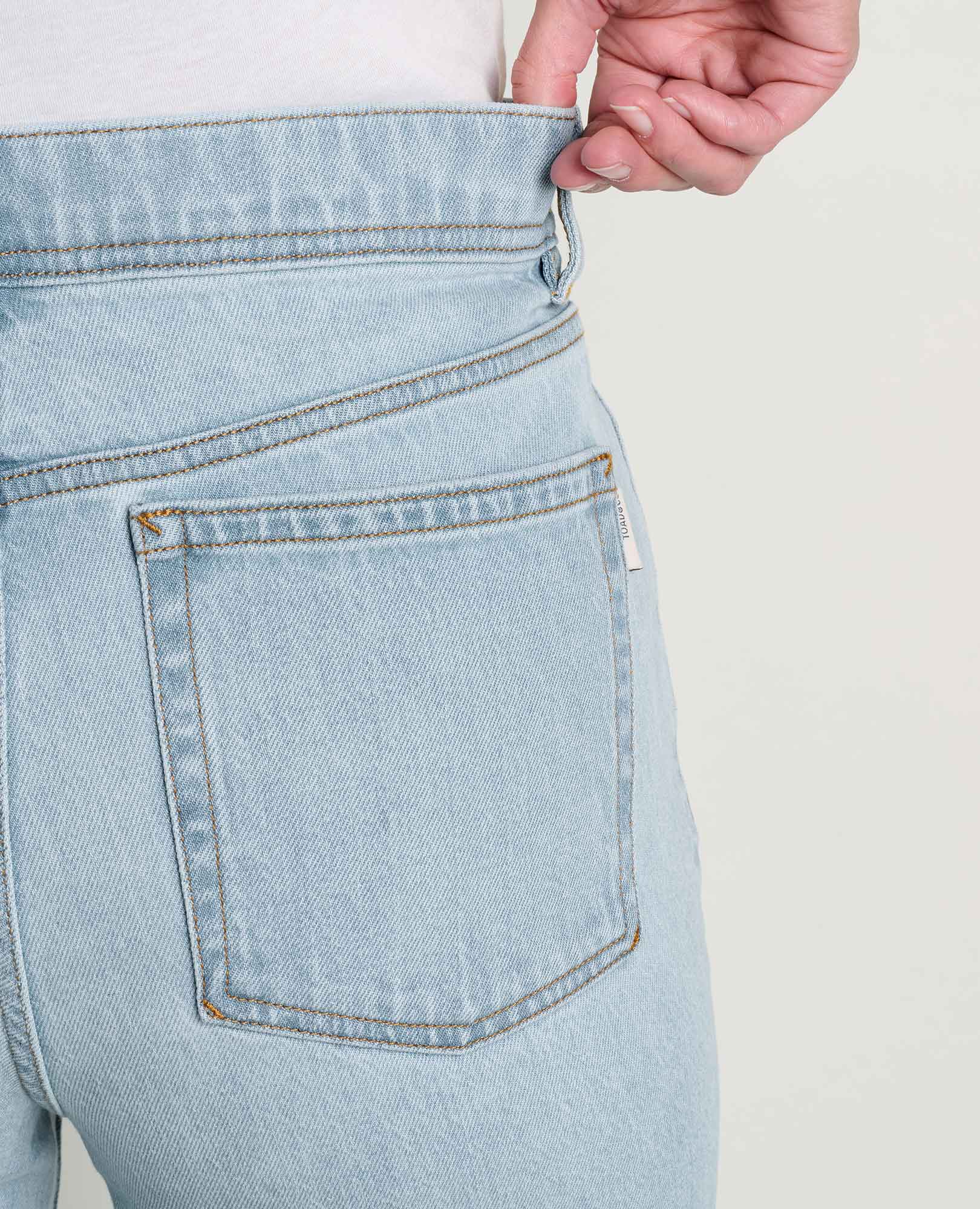Close-up back view of light wash straight leg jeans showing rear pocket and waistband detail