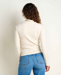Women's ribbed turtleneck long-sleeve top in cream, back view on model with jeans