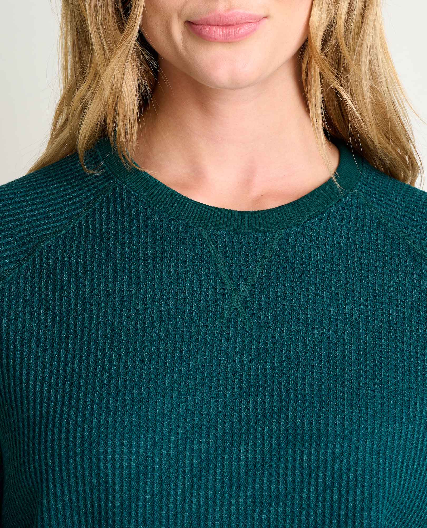 Close-up detail of ribbed knit crewneck pullover in deep teal, showing neckline and texture