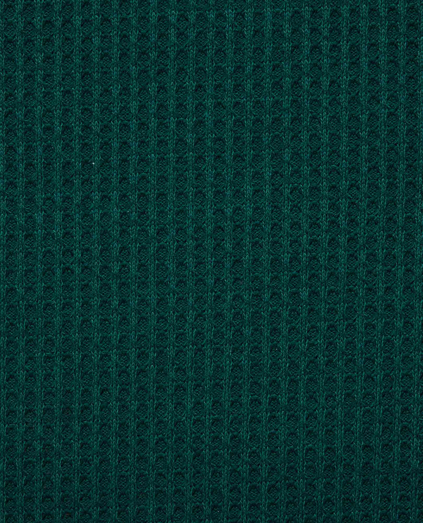 Close-up of dark teal waffle-knit fabric texture showing ribbed pattern detail