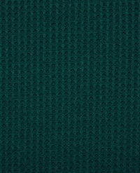 Close-up of dark teal waffle-knit fabric texture showing ribbed pattern detail