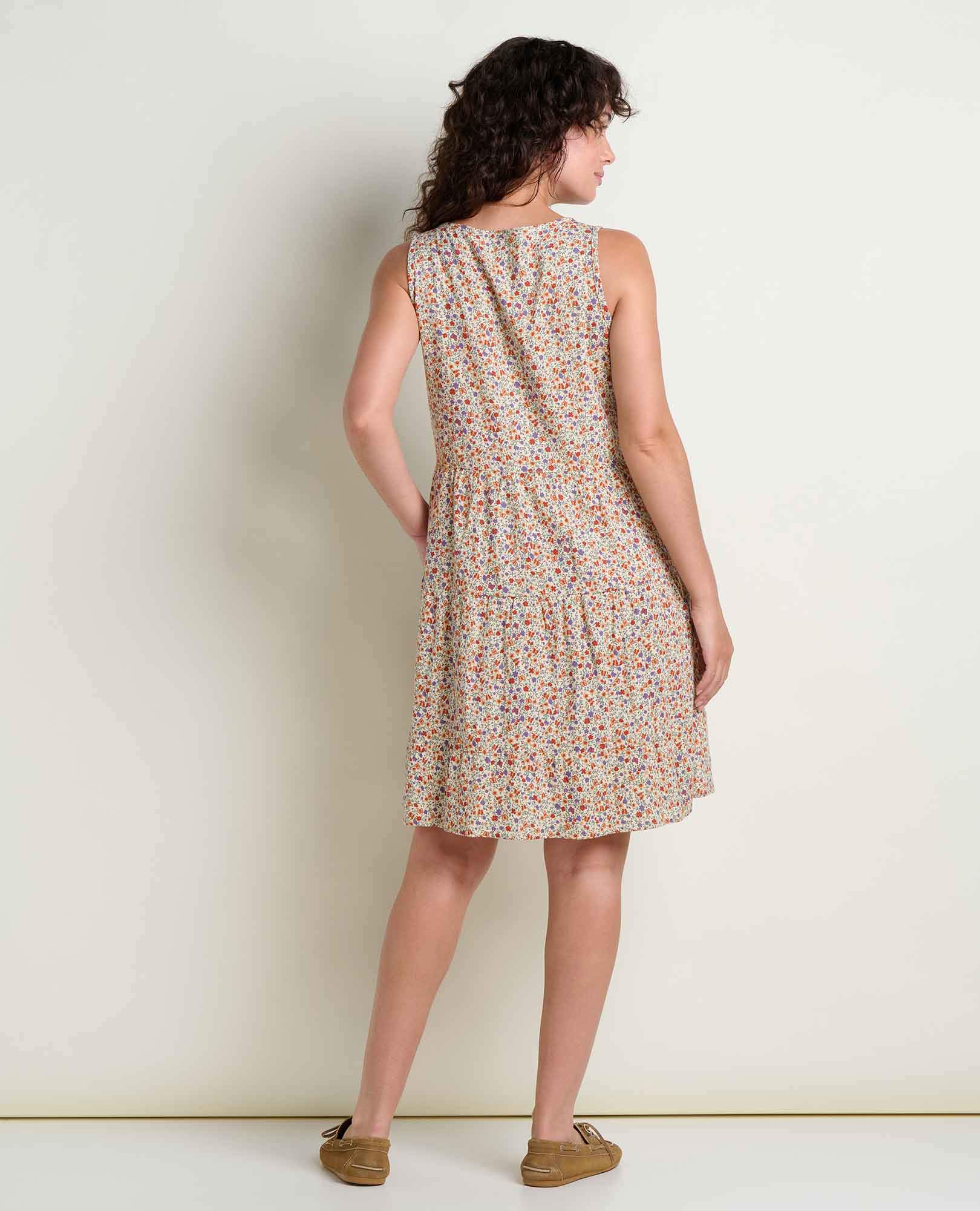 Sleeveless tiered dress with small floral print shown from back view on model