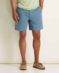 Men's chino shorts in dusty blue color worn with boat shoes, front view