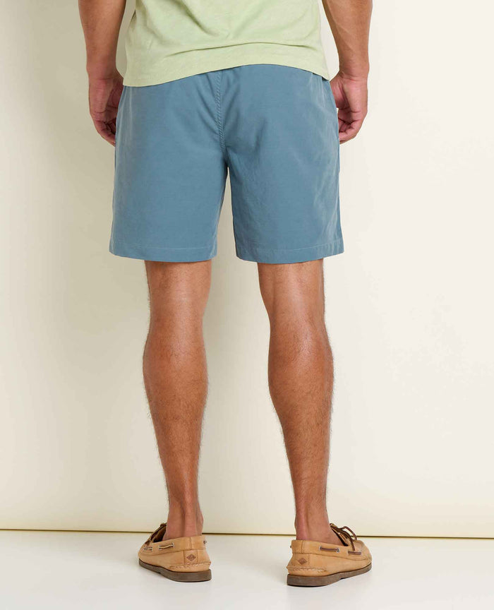 Men's chino shorts in dusty blue color shown from back view with boat shoes
