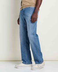 Men's straight-fit blue jeans, side view, worn with white sneakers and tan t-shirt