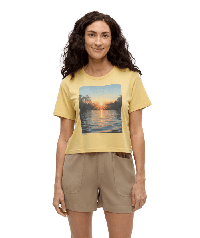 Yellow crop t-shirt with lake sunset graphic print, front view on model