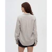 Light striped button-up shirt shown from back view on model with dark curly hair