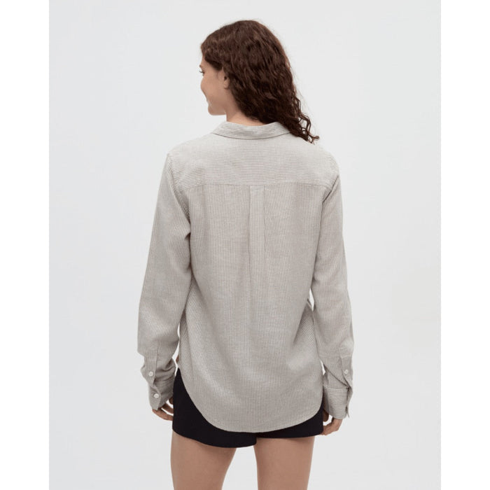 Light striped button-up shirt shown from back view on model with dark curly hair