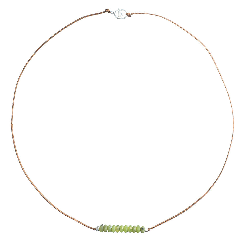 Minimalist cord necklace with green faceted stone beads centered on tan cord, silver clasp