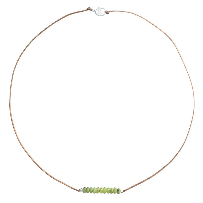 Minimalist cord necklace with green faceted stone beads centered on tan cord, silver clasp