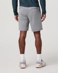 Men's grey heather performance shorts, back view, worn with teal long-sleeve and white sneakers
