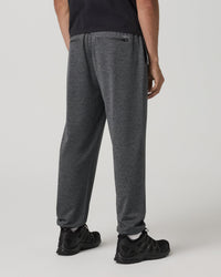 Men's heathered charcoal sweatpants back view with zip pocket and black athletic shoes