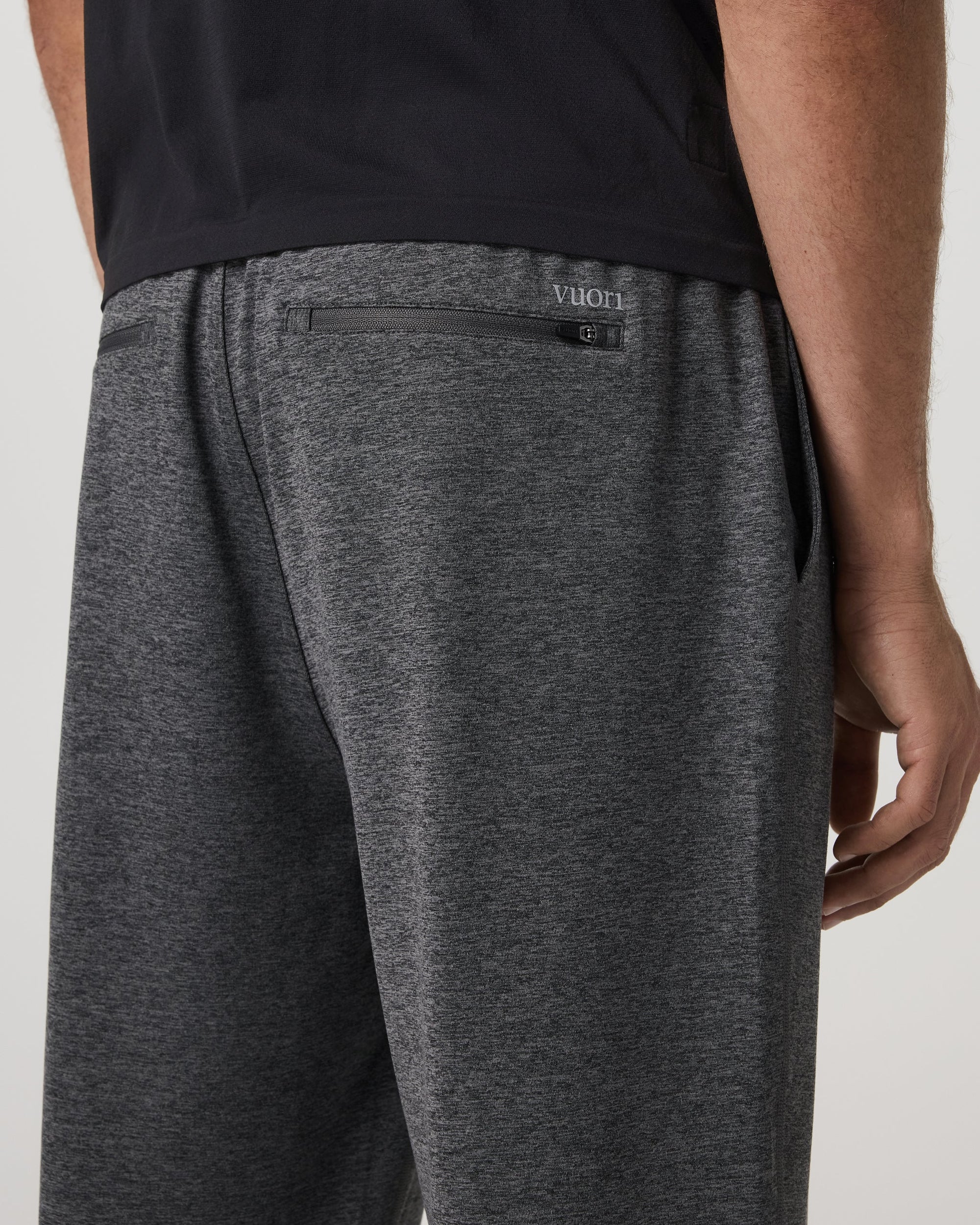Back detail view of men's sweat shorts showing zipper pocket and elastic waistband