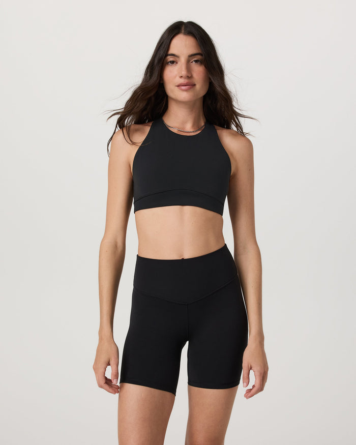 High neck sports bra in black, front view on model, sleeveless with racerback style