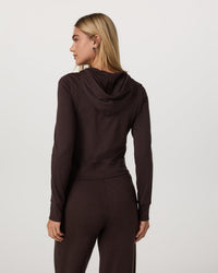 Women's cropped zip-up hoodie in dark brown, back view on model with matching pants
