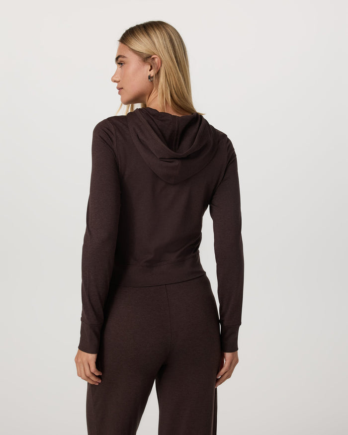Women's cropped zip-up hoodie in dark brown, back view on model with matching pants