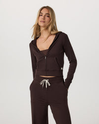 Women's cropped zip-up hoodie in dark brown, front view, paired with matching wide-leg pants