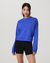 Women's blue crewneck pullover sweatshirt with ribbed hem, front view on model