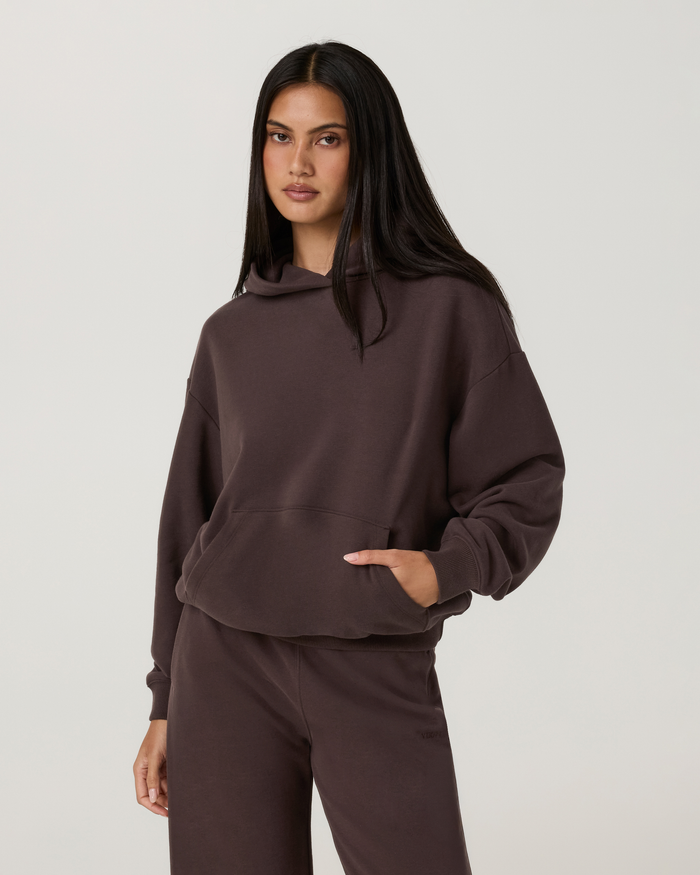Women's oversized pullover hoodie in dark brown, front view with kangaroo pocket