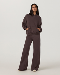 Women's oversized pullover hoodie with kangaroo pocket, paired with wide-leg pants, front view