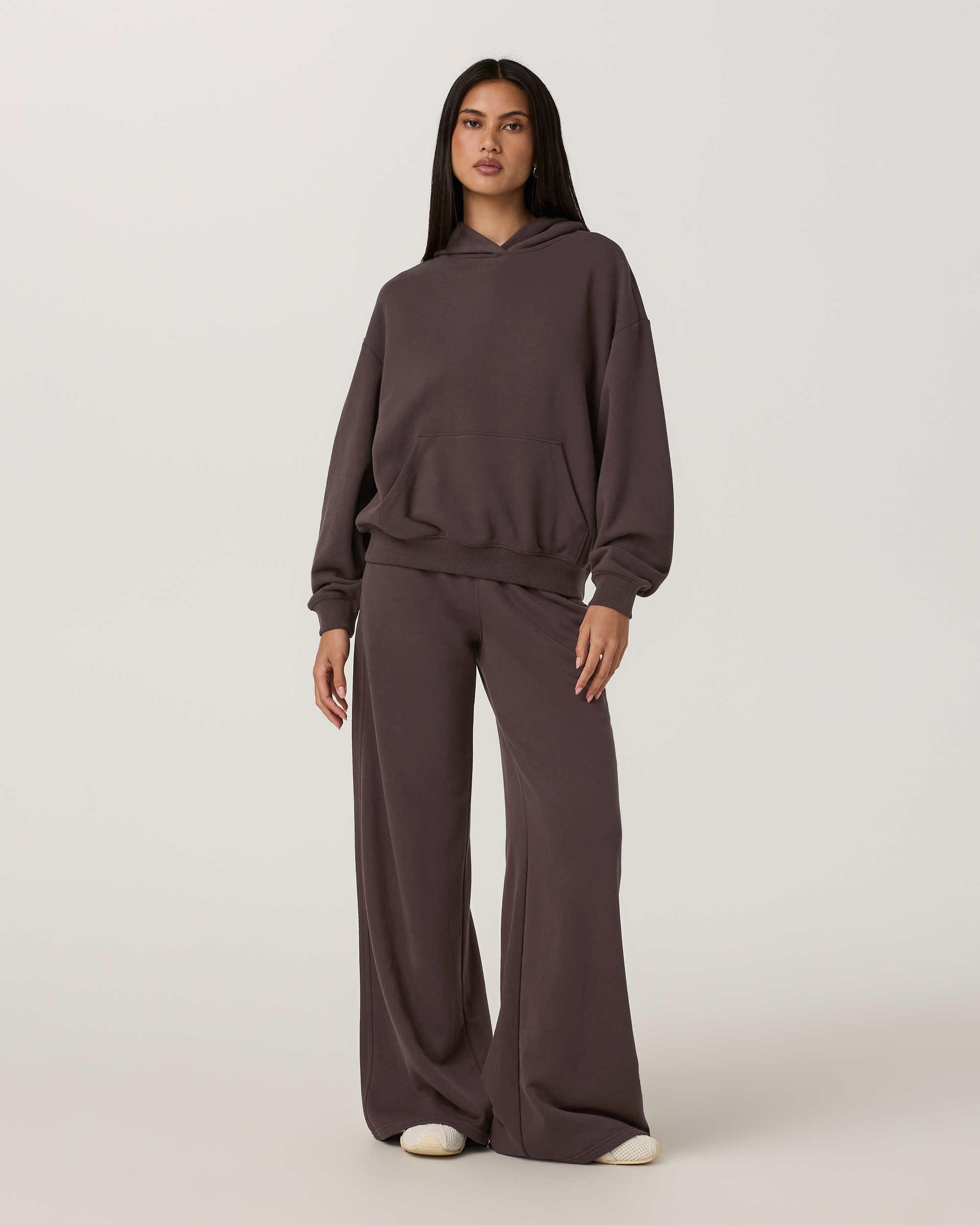 Women's oversized pullover hoodie with kangaroo pocket, paired with wide-leg sweatpants, front view