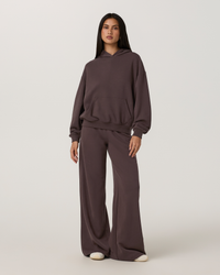 Women's oversized pullover hoodie with kangaroo pocket, paired with wide-leg sweatpants, front view