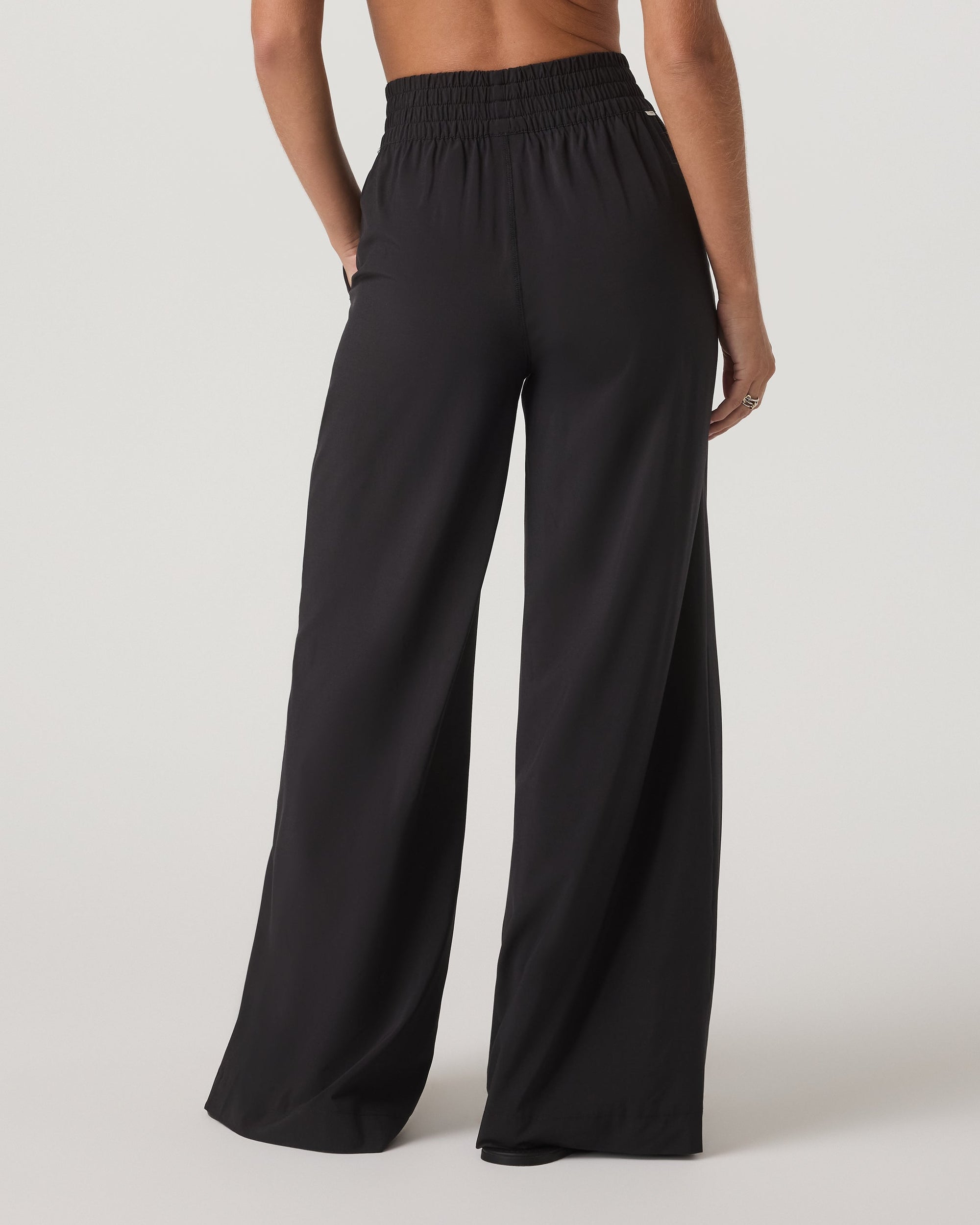 Wide-leg black pants with smocked elastic waistband, back view on model