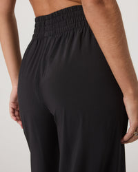 Back detail view of high-waisted wide-leg pants with smocked elastic waistband in black