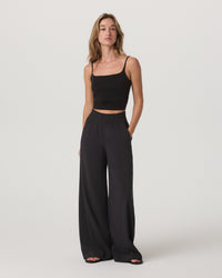 Black wide-leg flowy pants with smocked waistband, full-length front view on model