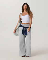 Wide-leg grey sweatpants with midrise waistband, shown full-length on model with tote bag