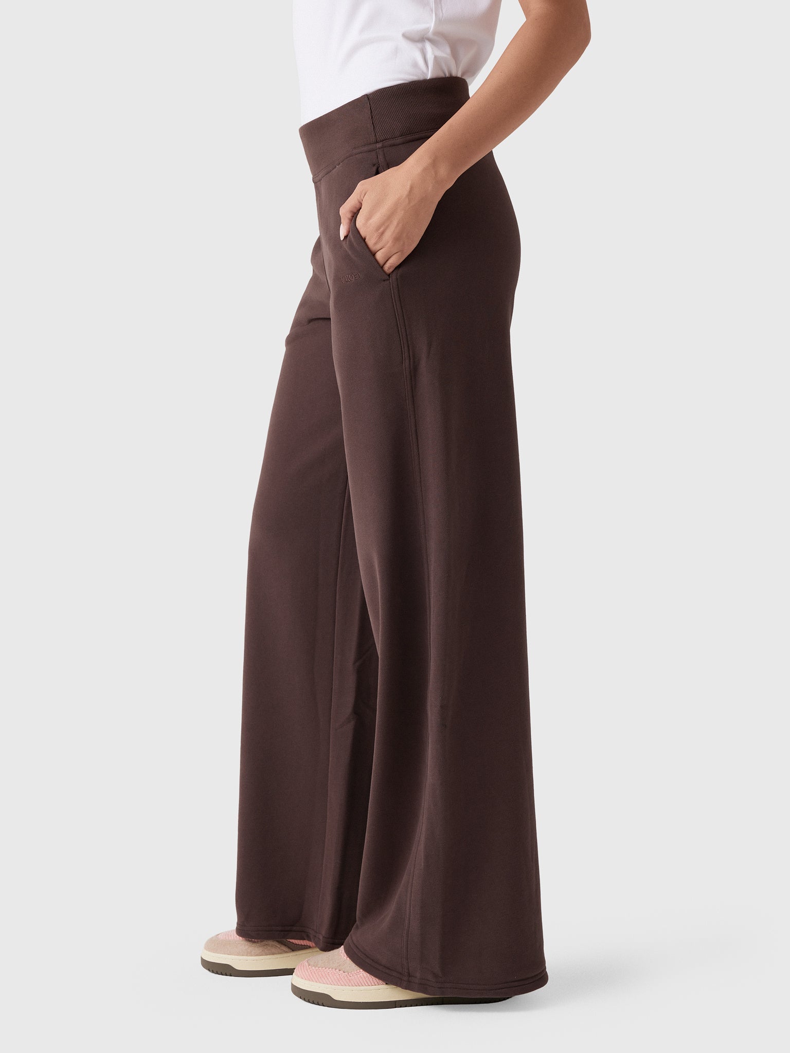 Wide-leg high-waist dark brown sweatpants with side pocket, side view on model