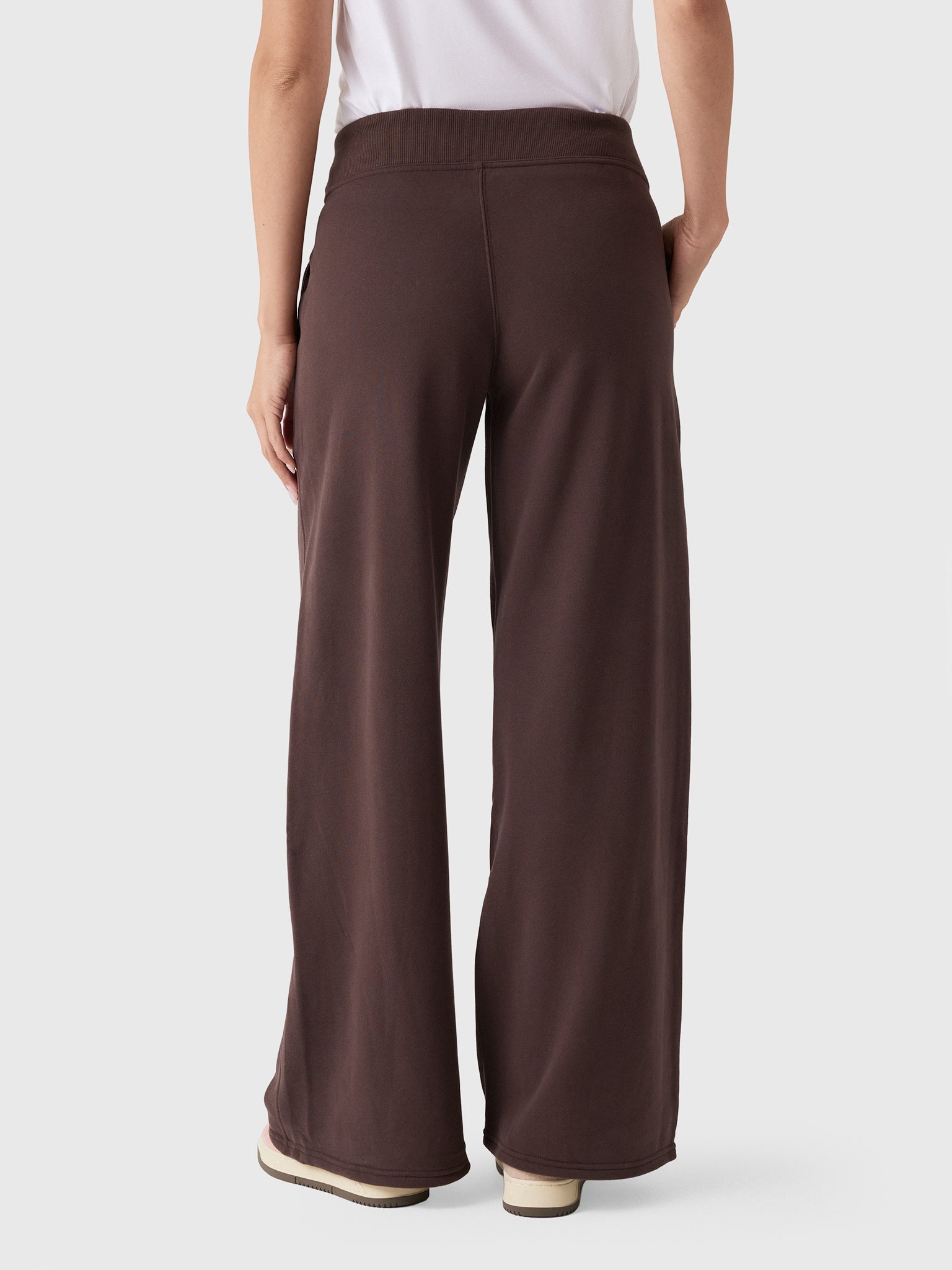 Wide-leg sweatpants in dark brown, back view, showing elastic waistband and relaxed silhouette