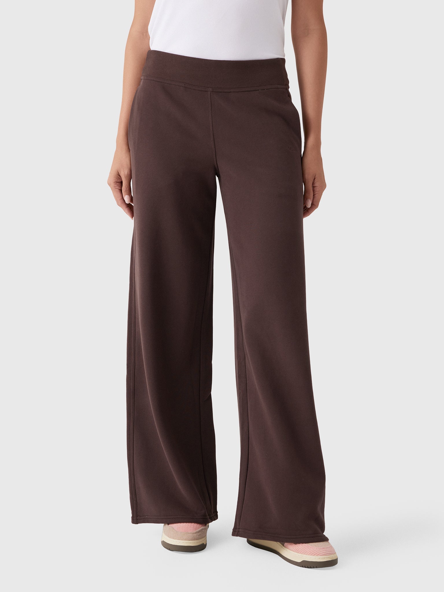 Wide-leg dark brown sweatpants with mid-rise waistband, front view on model