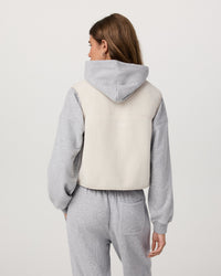 Women's sherpa fleece vest in off-white, back view, worn over grey hoodie