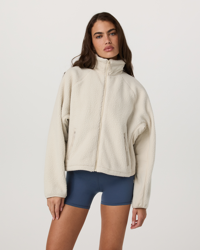 Women's cream sherpa fleece full-zip jacket with stand collar, front view on model